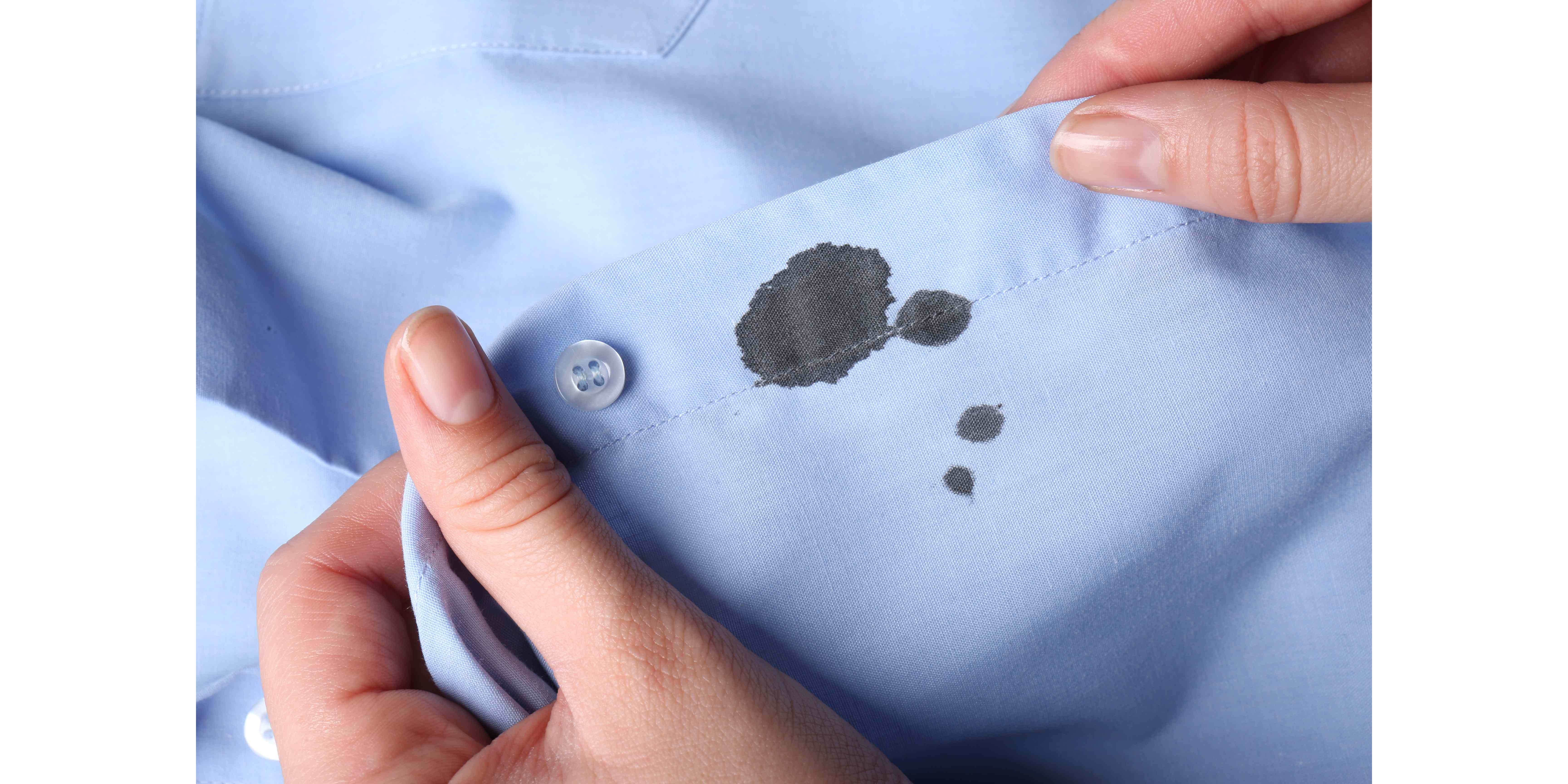 woman holding shirt with black ink stain closeup