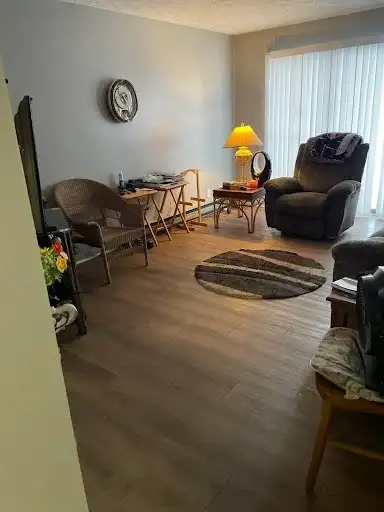 Cozy, clean living room with polished floors, a tidy sofa after professional house cleaning by The CoBuilders