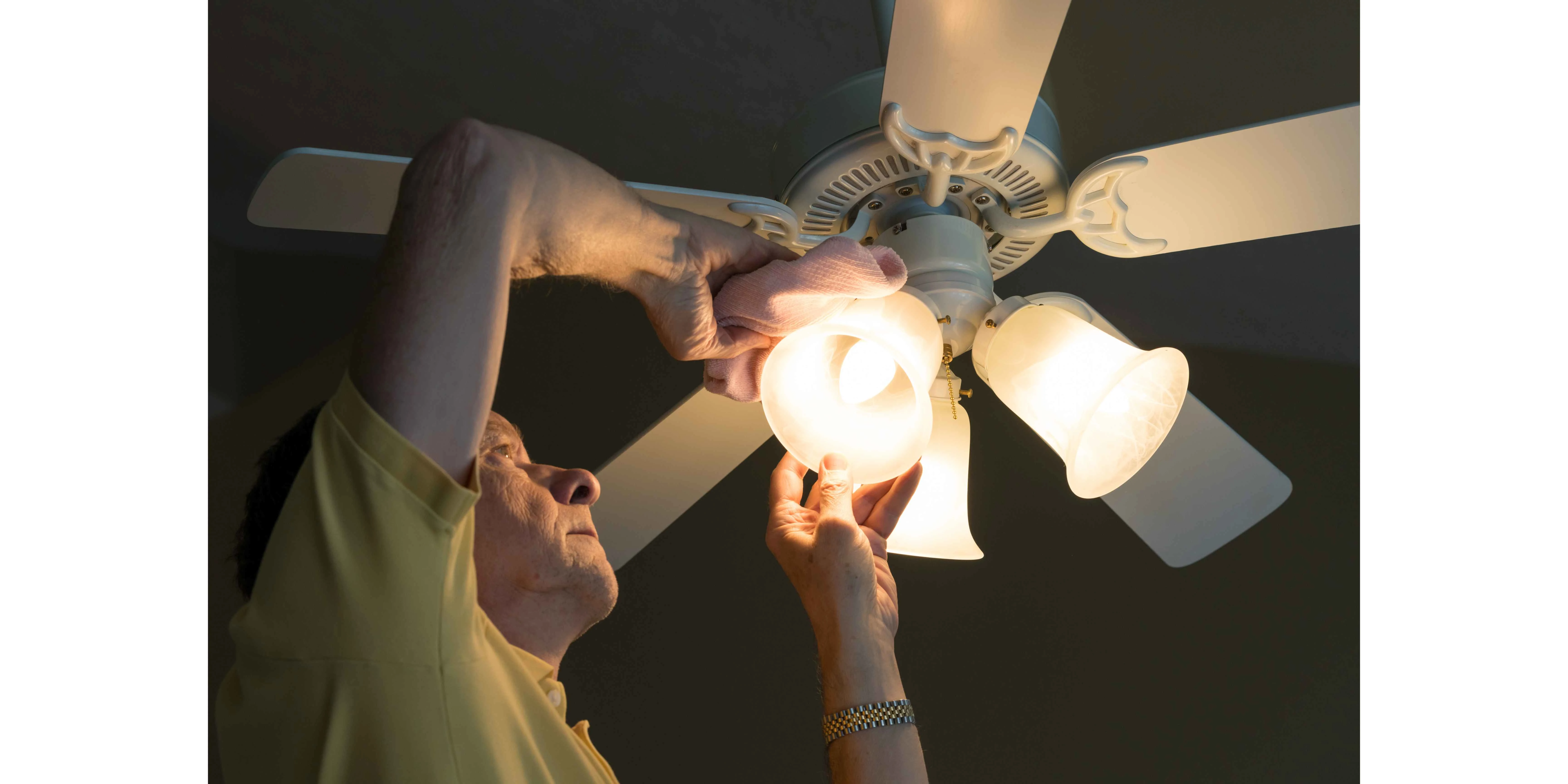 picture of a man cleaning a ceiling fan