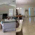 Professional cleaner with "The CoBuilders" label on their uniform wiping down empty kitchen during move out house cleaning in Denver Colorado