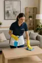 Professional maid with "The CoBuilders" label on their uniform, cleaning a modern living room to deliver a spotless home environment
