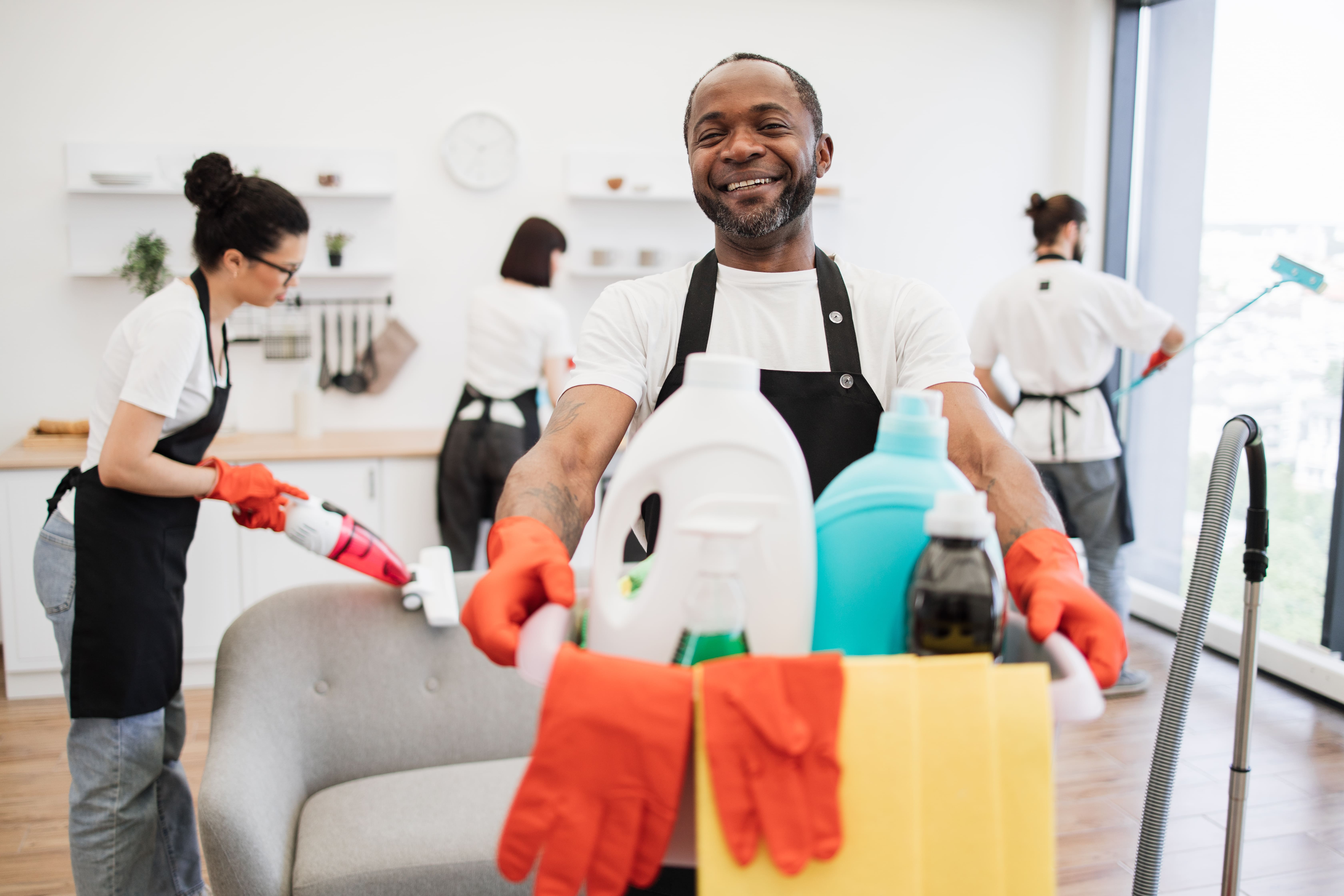 diverse group of male and female cleaners cleaning a home
